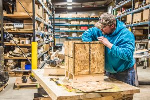 A Marine Travelift employee builds a custom shipping crate to ship a special machine component